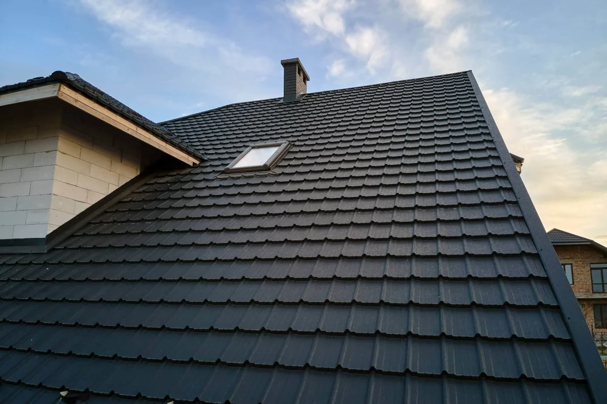 A pitched roof finished in dark flat-profile tiles